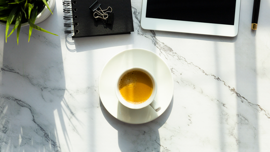 Morning espresso on a sleek marble desk with notebook and tablet — ideal back-to-work setup for staying energized and alert