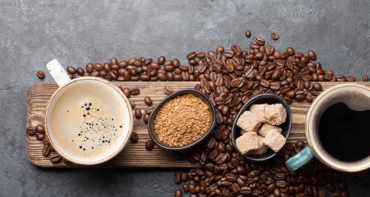 Aromatic coffee cups surrounded by roasted beans and raw ingredients on a rustic board