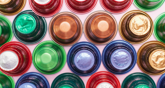 Multi-colored coffee machine capsules arranged neatly, representing brand variety and compatibility